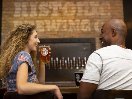 a man and woman enjoying pints of beer and good conversation at a Flagstaff, AZ brewery