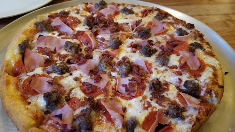 A pizza that's topped with ham and sausage at NiMarco's Pizza in Flagstaff, AZ.