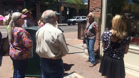 People walking downtown looking at stone buildings