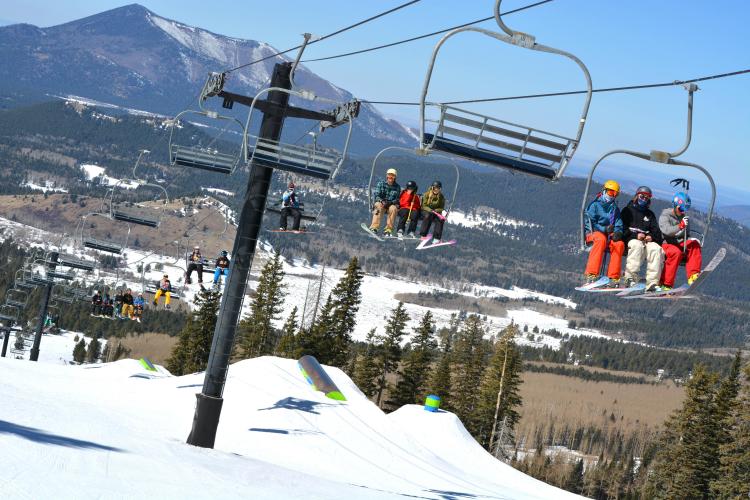 skiers riding ski lift