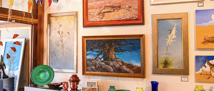 Several pictures on a gallery wall of a First Friday Artwalk gallery in Flagstaff AZ