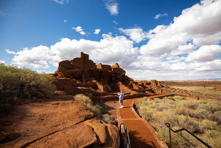 person taking a photo of the Wupatki National Monument