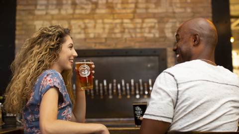 a man and woman enjoying pints of beer and good conversation at a Flagstaff, AZ brewery