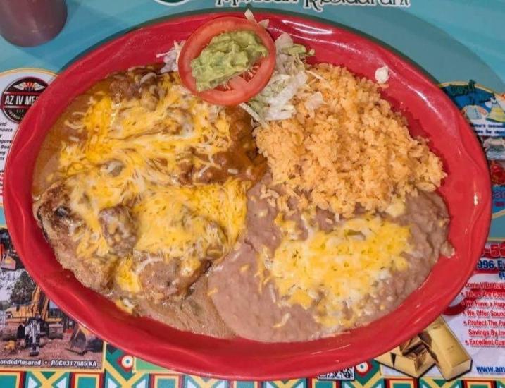 A plate of rice, beans, and enchiladas with red sauce from La Fonda Mexican Restaurant