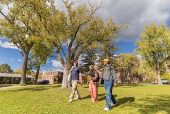 NAU students chatting and walking in the grass in north campus.