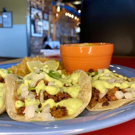 Three tacos with green sauce from Salsa Brava