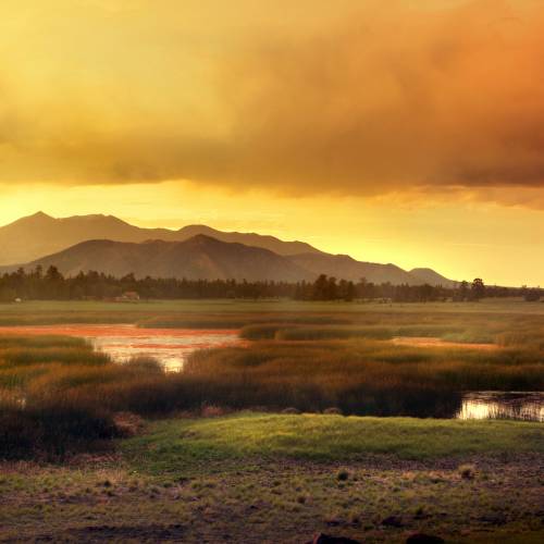 red sunset over mountain meadow