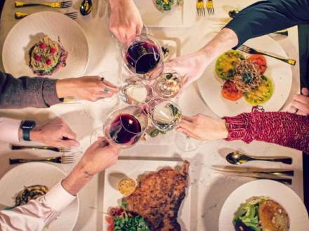 People cheering with wine and food at Teatro in Flagstaff, AZ.