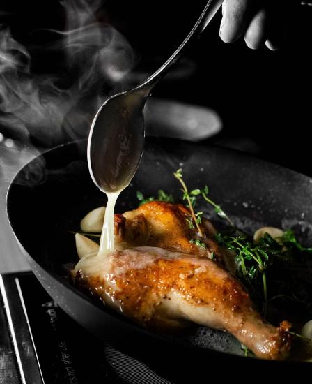 A chef pours jus on cooked chicken at Tinderbox Kitchen in Flagstaff.