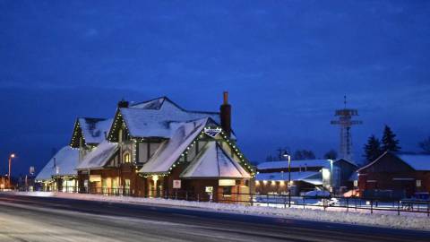 snow covered Historic Flagstaff Visitor Center decorated with lights in the evening
