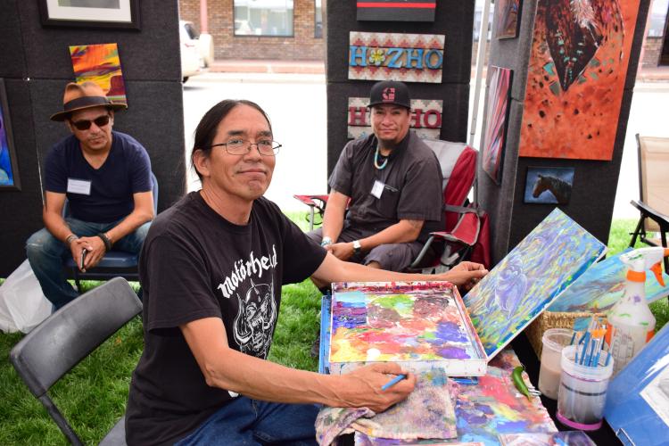 An artist works on a painting at Art in the Park.