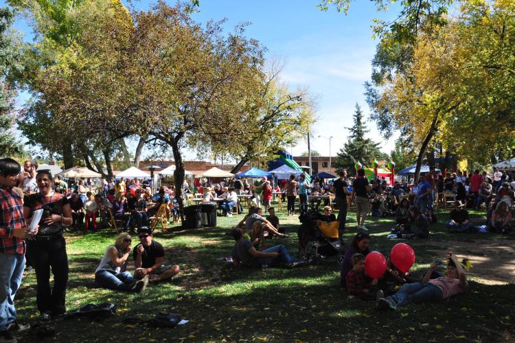Crowds of people talk and stroll through vendors at Art In The Park.