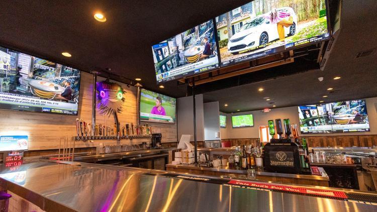The interior of Dirty Birdies Sports Bar & Grill with a large bar and television screens