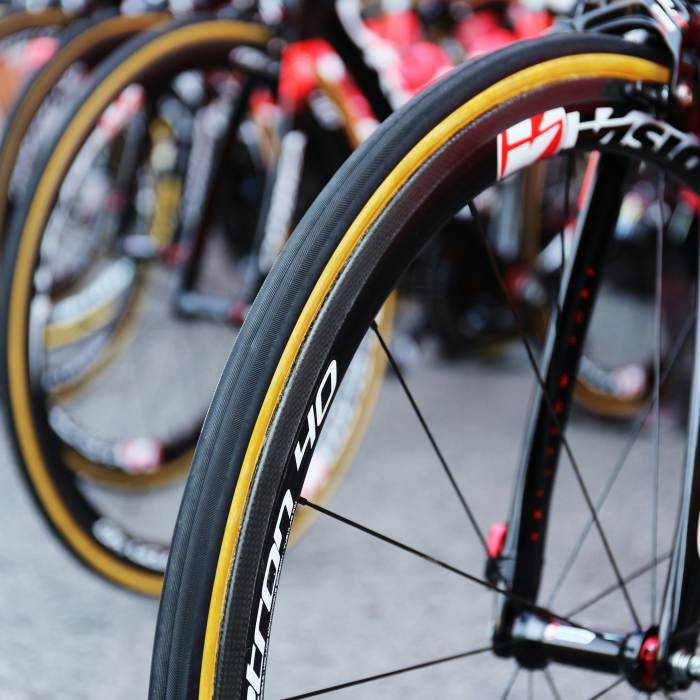Close up of a row of bike tires. The tires are black with a yellow stripe