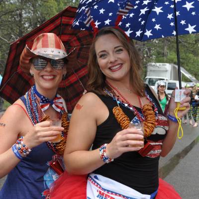 Two women wearing red white and blue clothing hold beers on Fourth of July in Flagstaff
