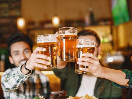 friends toasting pint glasses of beer