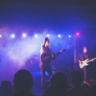 Musicians on a stage with purple lights