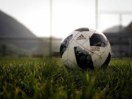 A black and white soccer ball sitting in the grass