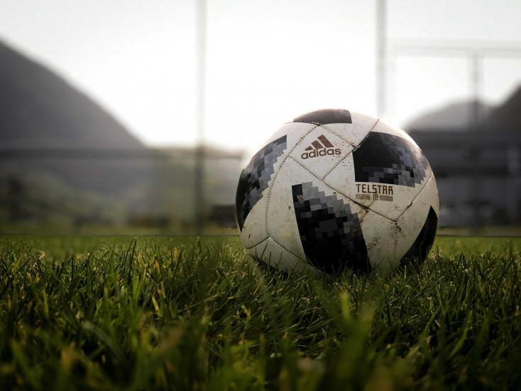A black and white soccer ball sitting in the grass