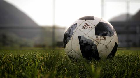 A black and white soccer ball sitting in the grass