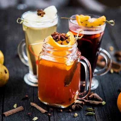An array of seasonal mocktails with oranges and pears.