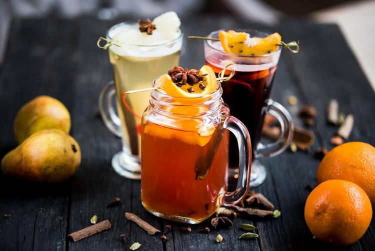 An array of seasonal mocktails with oranges and pears.