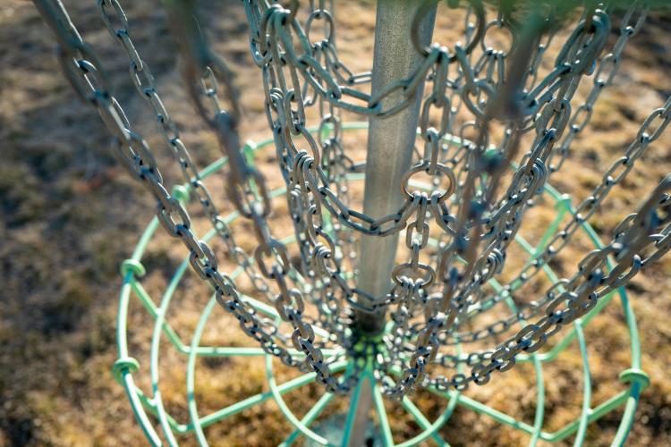 Close up, high angle shot of the inside of a metal disc golf basket. 