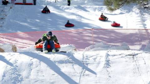 people snow tube down a snow covered mountain at Flagstaff Snow Park